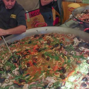 Many Huge Pans Cooking Spanish Paella. Street Food Fair in Italy