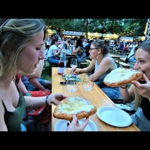 Street Food in Budapest, Hungary. Preparing, Cooking and Eating Traditional 'Langos'
