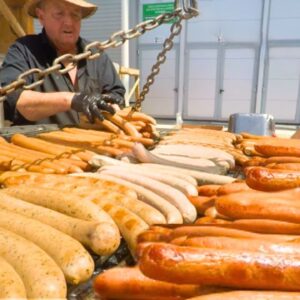 Gigantic Bratwursts on a Circular Grill, Huge Rotisserie, Irish Meat. Street Food Event in Italy